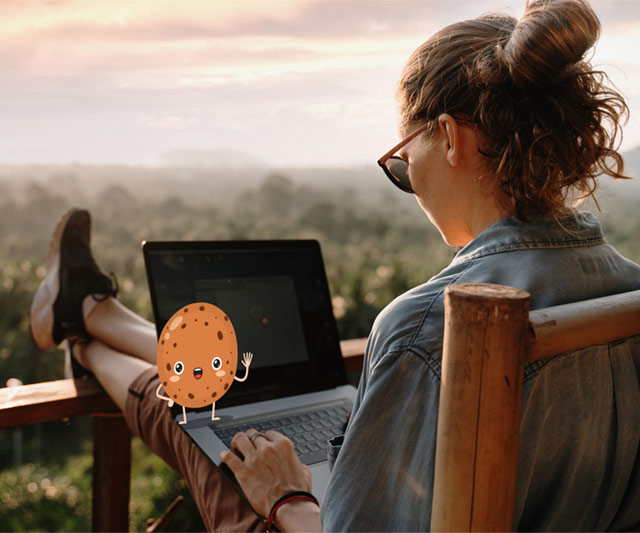 A cookie-man on a computer while a woman is using it